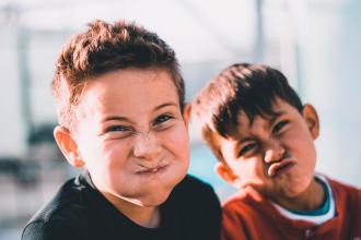 
		Two children laugh into the camera
	